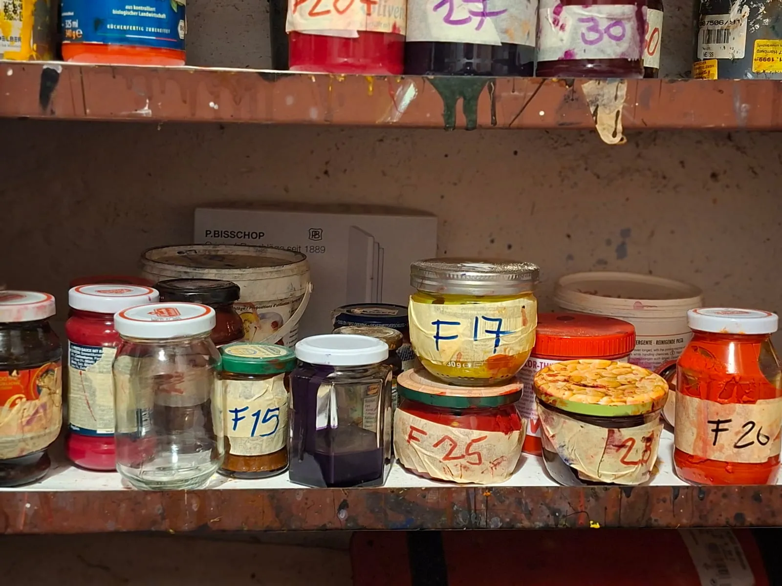 Jars stored upside down holding hand-mixed printing inks, numbered