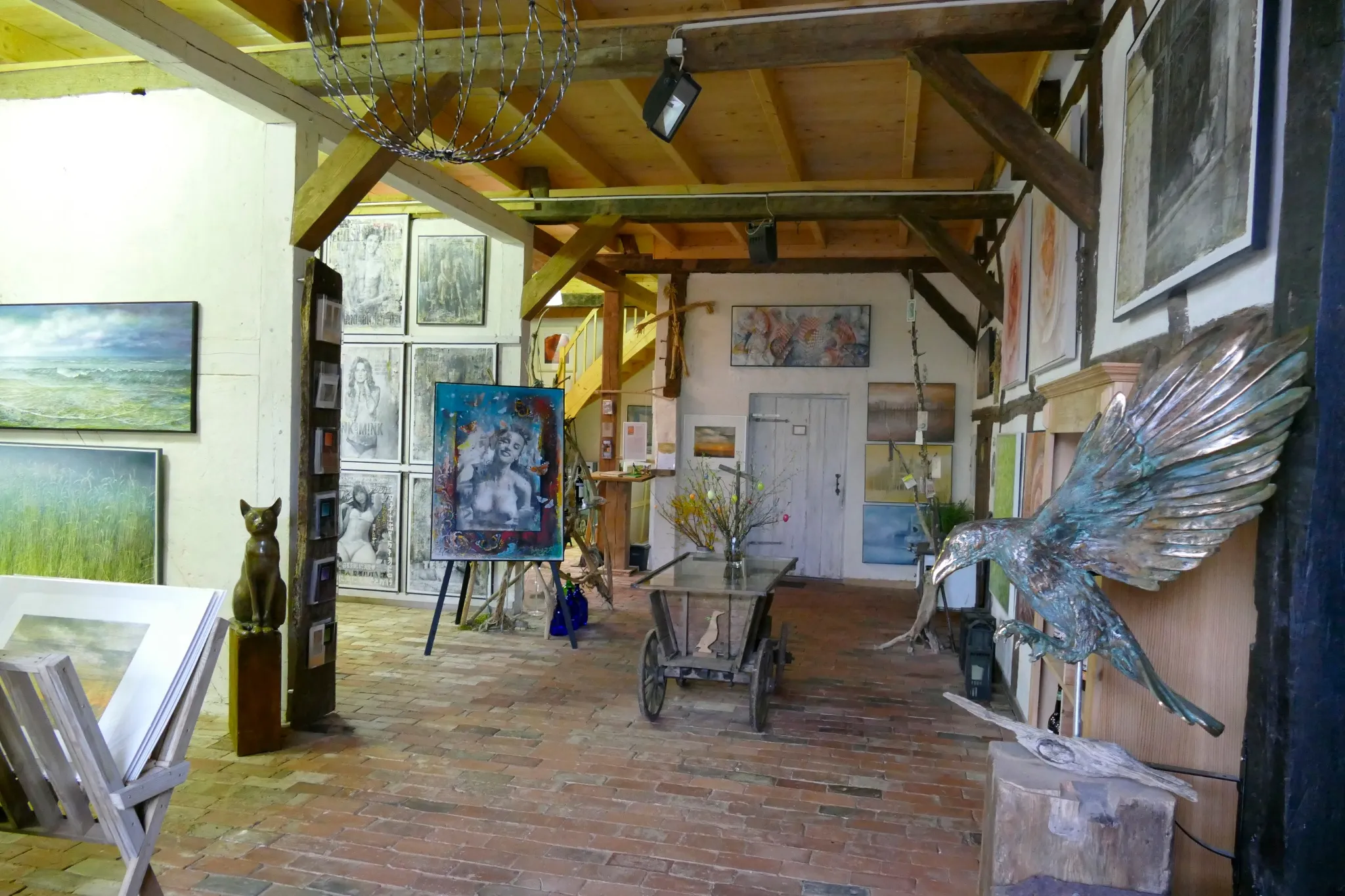 Ground-floor exhibition room with paintings and a bronze sculpture