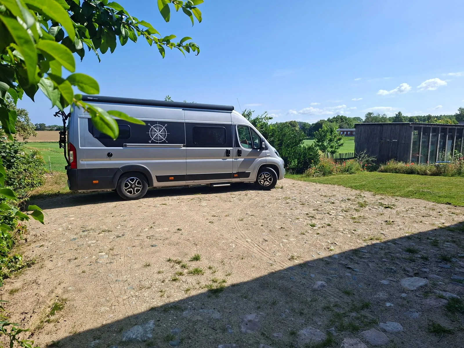 Motorhome on the pitch with trees and open countryside behind