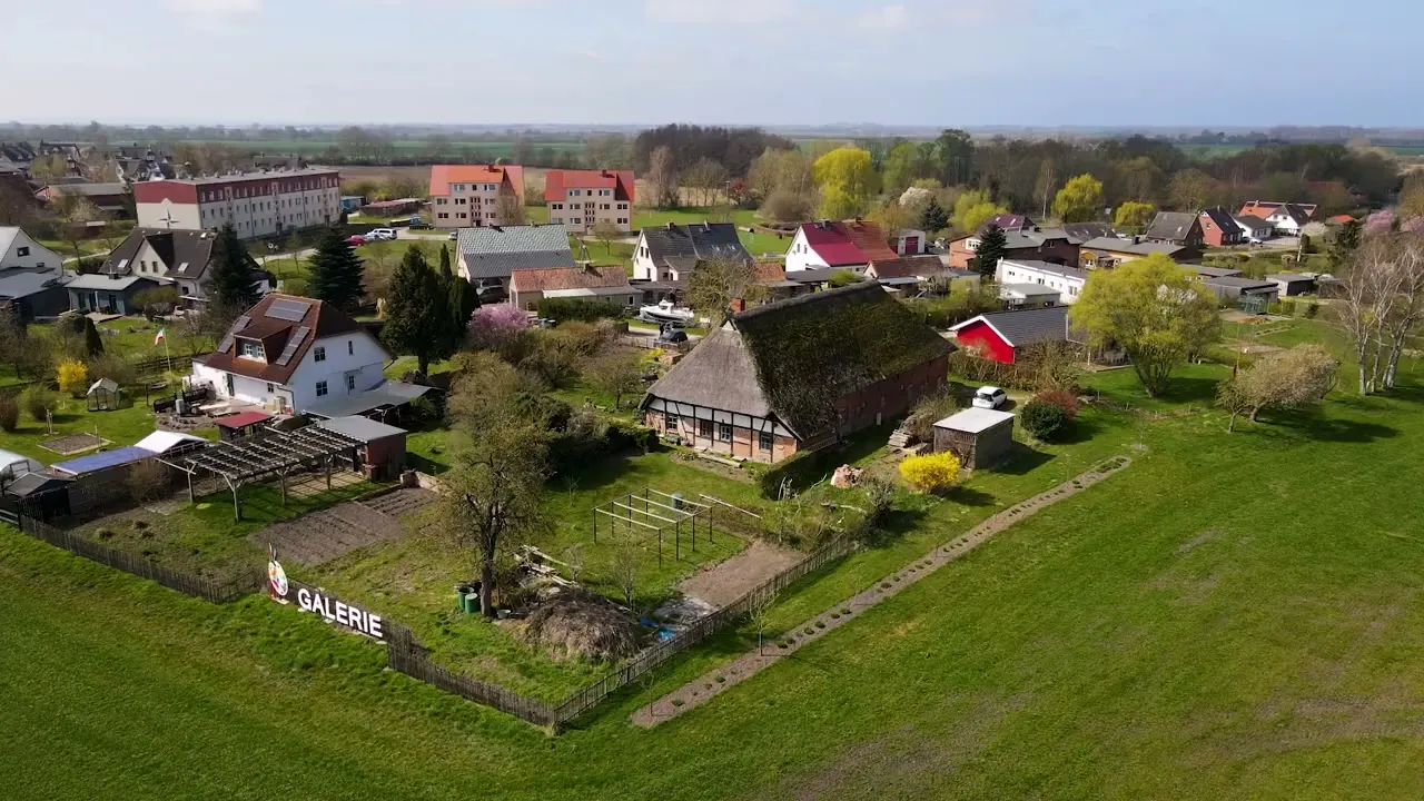 Aerial view of the thatched farmstead with gallery and pitch by the open countryside