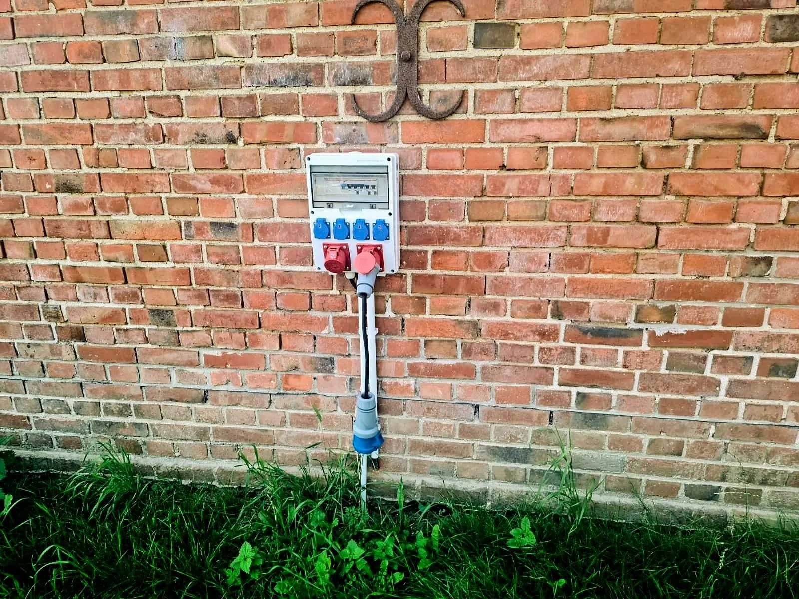 Weatherproof power distribution box on the brick wall with fuse box and several sockets